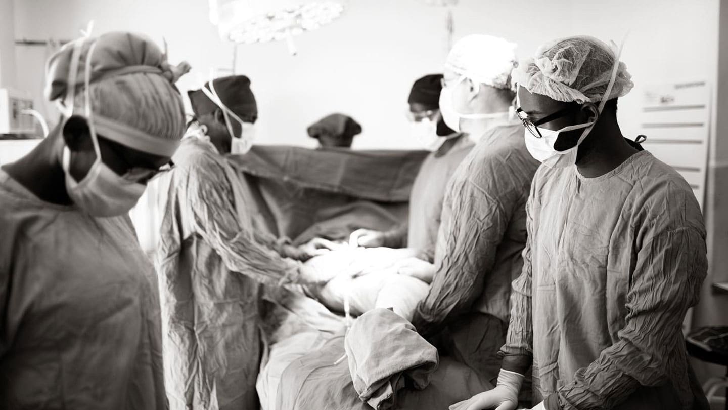 hospital staff in scrubs performing surgery