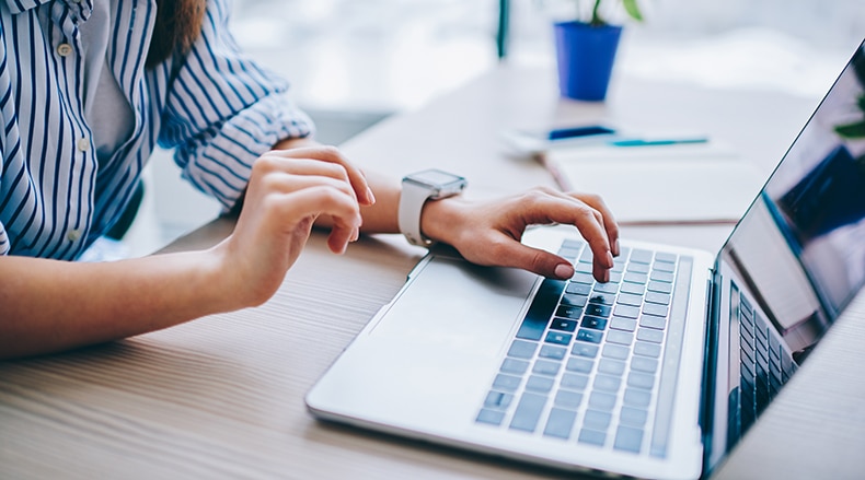 This image shows someone using a computer, representing the importance of carefully planning your donor management software search.