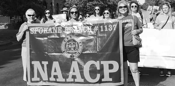 Grayscale image showing protestors with banner that says Spokane Branch 1137 NAACP