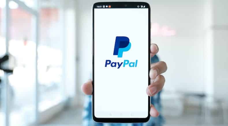 PayPal para la imagen del encabezado sin fines de lucro que muestra a la persona que posee iPhone con logotipo de PayPal